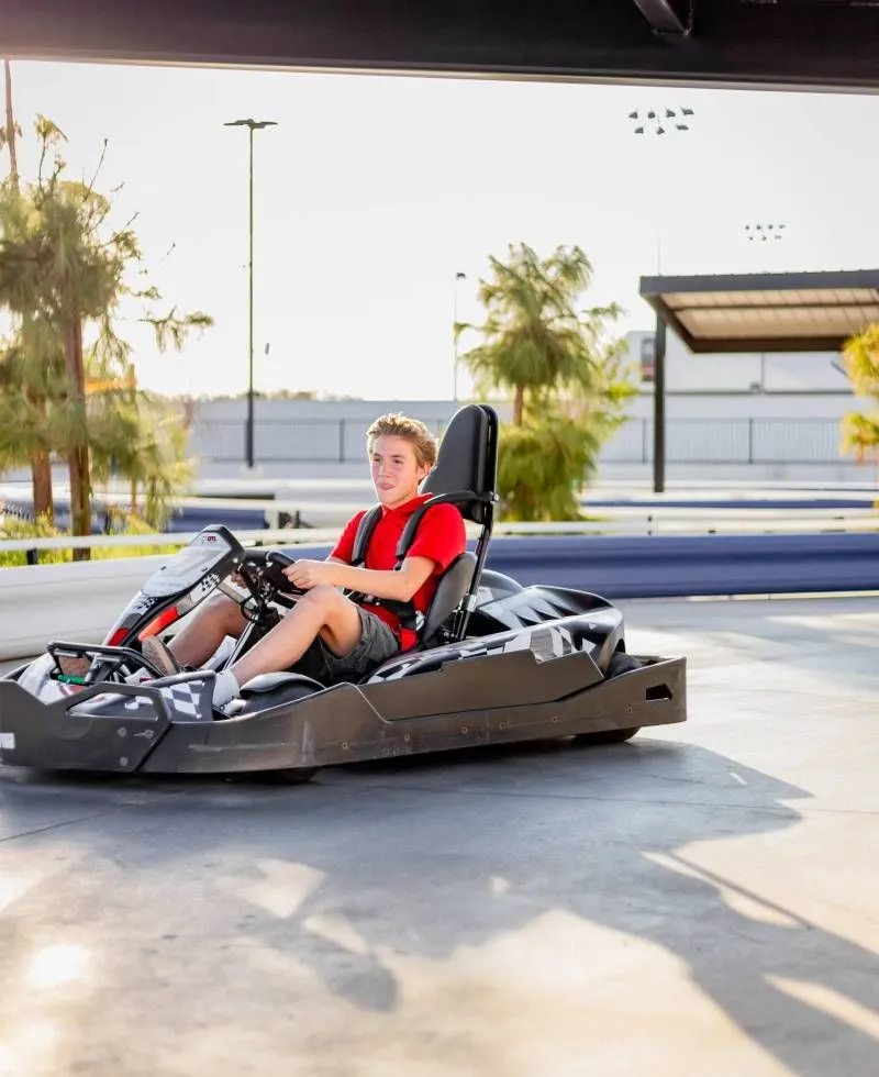 Child driving a go-kart under the canopy on the Pecan Lake track