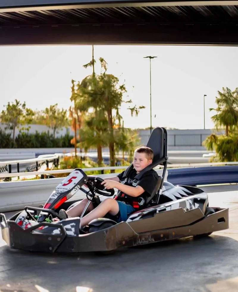 Child driving a go-kart under the canopy on the Pecan Lake track