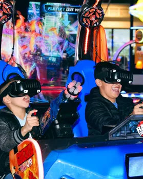 Kids racing on an arcade driving game at Pecan Lake Entertainment in Queen Creek, AZ
