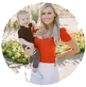 Woman holding a child outdoors, both smiling, with a bright, circular blurred background.